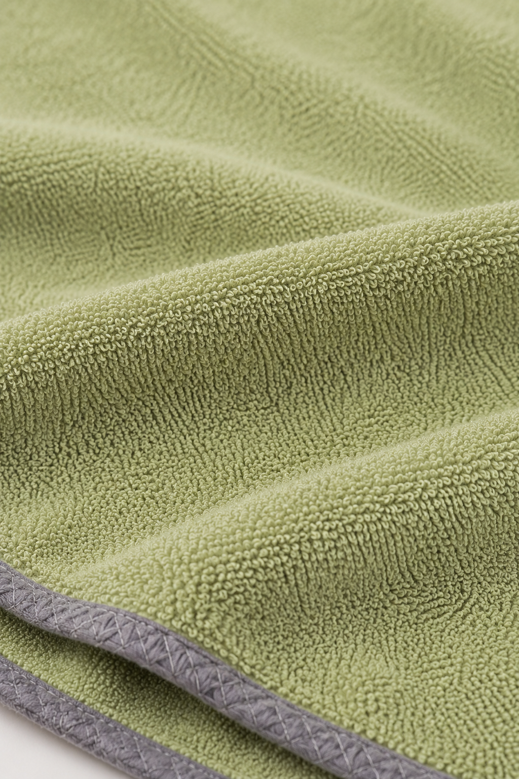Woman wearing the Summer Robél wearable towel in green against a beige background